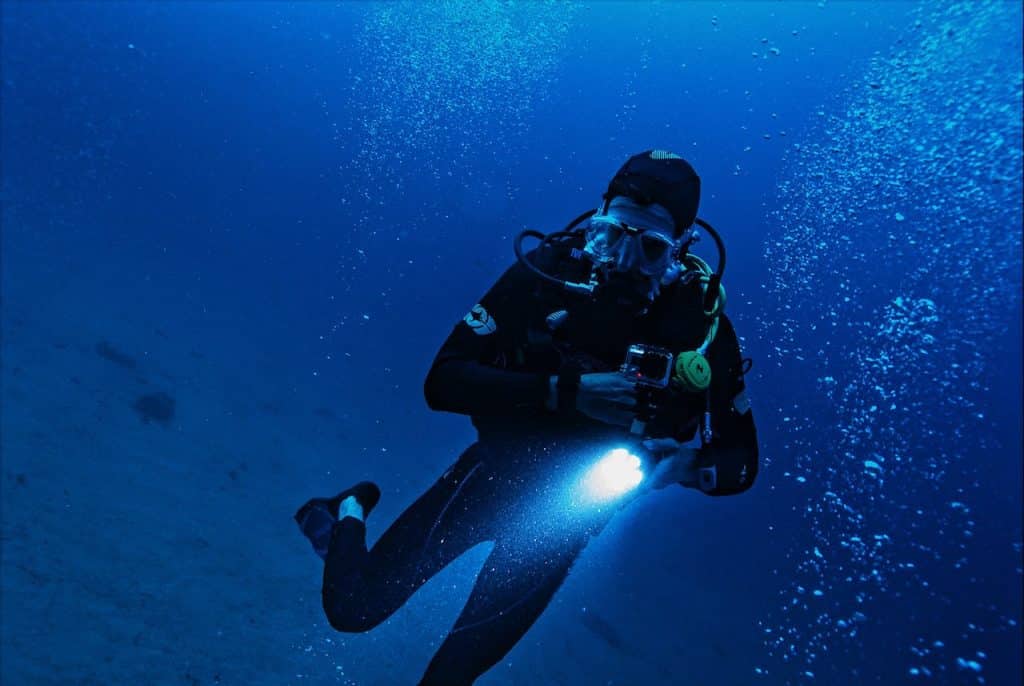 Man Underwater with light and gopro
